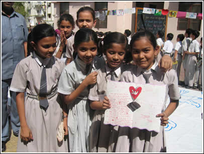 A girl at H.B. Kapadia shows off her letter. 