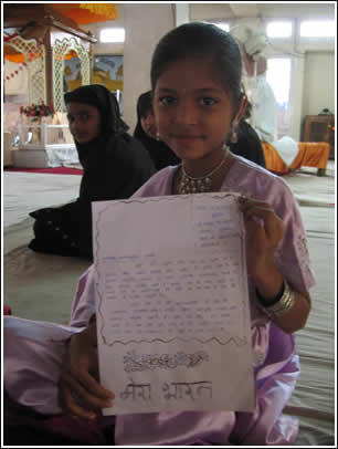 A small Hindu girl shows off her letter at the Gurudwara before the march. 