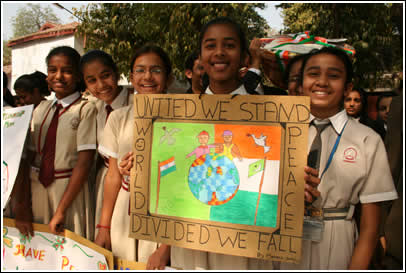 Girls present sign saying "United We Stand". 