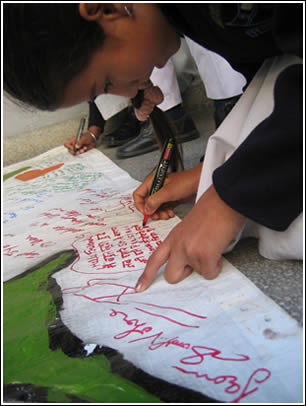 A girl writes her special message on a border piece. 