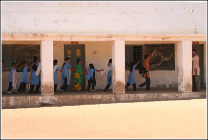 Maria leads a chain of school girls in playtime!