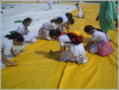 Pakistani girls sign on the yellow strips of The World's Largest Love Letter. These yellow strips will soon be famously known as "The Golden Bridge of Friendship." 