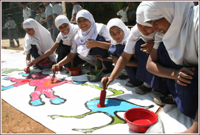 Students at Allana High School help paint the border tarps.