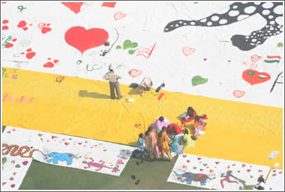 School kids sign a banner piece. Each banner is signed by a school from India and will be given to a school in Pakistan, creating school-to-school penpal relationships.