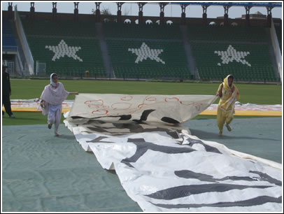 Pakistani volunteers help fold up the enormous letter strips after the huge event. 
